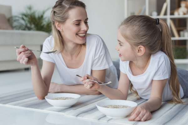 Mother daughter eating cereal Getty