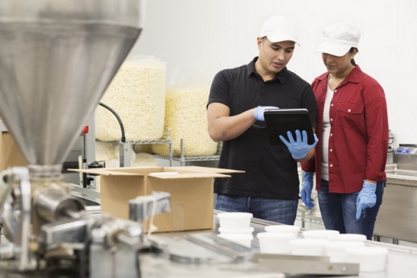 Snack factory tech workers using tablet Getty